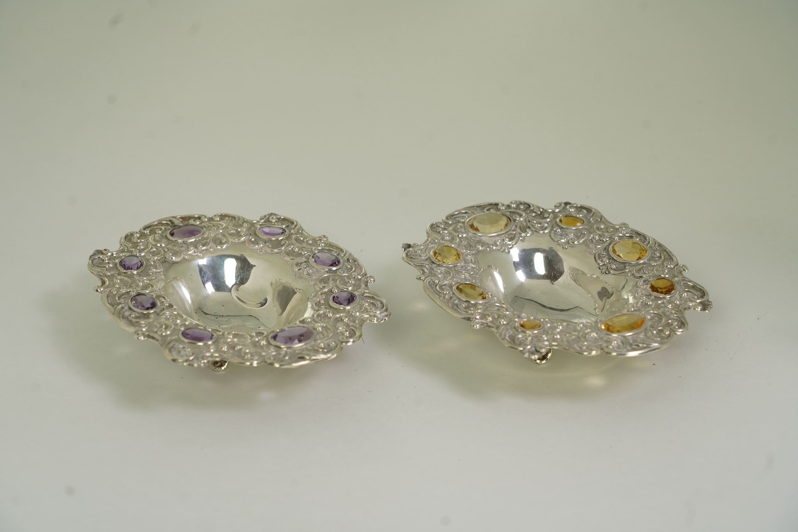 Two unusual late Victorian repousse silver dishes, by Daniel & John Welby, one border inset with eight oval cut amethysts, the other with eight oval cut citrines